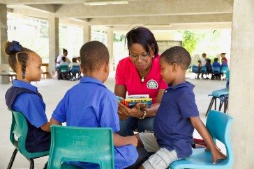 OECS Commission Staff reading to students as part of the USAID/OECS ELP 