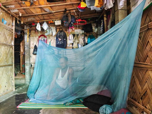 Abul, a volunteer NGO worker and father of four, rises early to get ready for work. With cases of dengue fever on the rise in the camps, he encourages his family to take precautions by using mosquito nets. Cox’s Bazar, Bangladesh, October 2023 © Ro Yassin Abdumonab