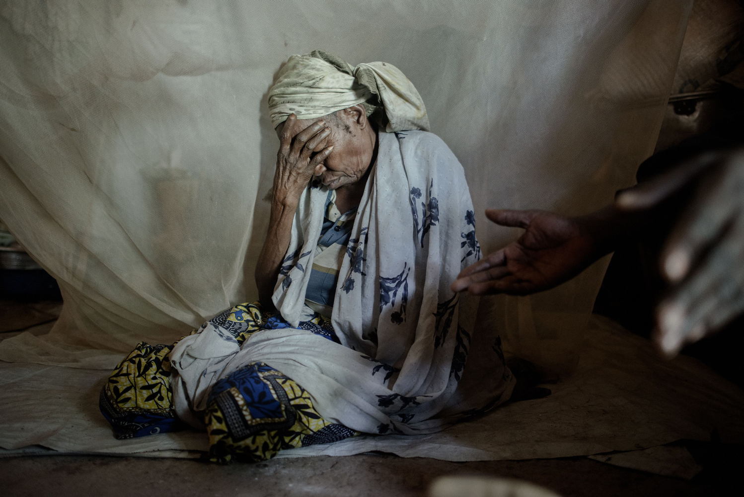 65 year old Amine at a at a camp for displaced people at the Central Mosque in Bangui.

Amina is from Bouca in the north of the country. One morning around 5am, armed groups surrounded her neighbourhood and pushed all Muslims inside a house and then set the house on fire. Amina was in a neighbour’s house watching the scene from the window. She was saved thanks to a Christian who protected and allowed her and some other mothers to escape. Amina found her four daughters and fled. One of her daughters paid for a ticket to go to Bangui while her daughters fled to Chad. That was three years ago, Amina often calls her daughters who now live in a refugee camp in Chad. Hachta (40), Apsita (35) and Kadidja (28) are healthy but have not been able to find work. Mariam (30), her fourth daughter died at his arrival in the camp following an illness. Amina would like to join her daughters but due to lack of money, she cannot. Today Amina survives thanks to the solidarity of the displaced families in the mosque, and the distribution of food in the camp.
