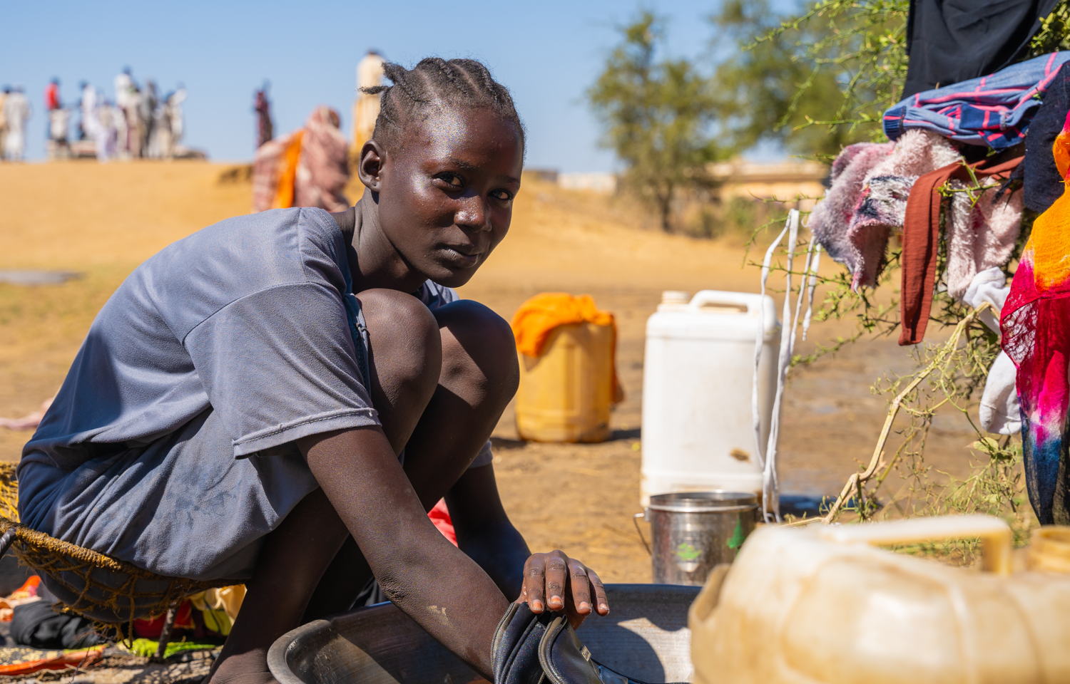 Eman, 18 jaar, doet de was naast een stilstaande poel in Jerbana. Zij en haar familie zijn afhankelijk van deze poel om te koken, te drinken en te baden. © Isaac Buay/MSF