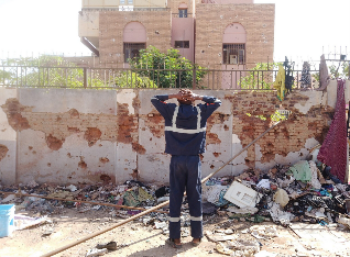 A man looking at a wall struck by a shell in Khartoum. April 2023