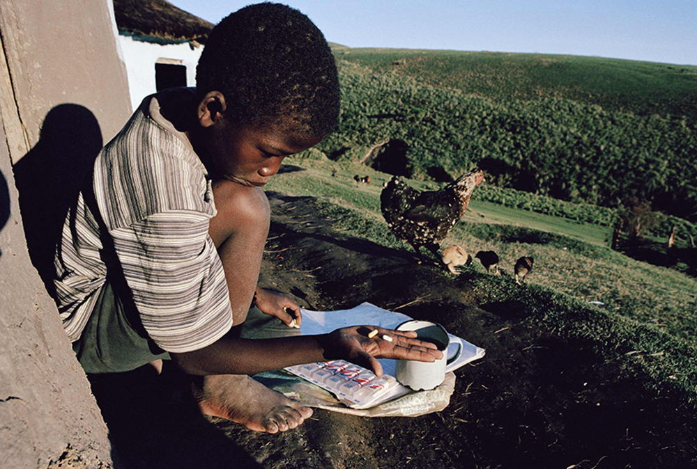 ©Gideon Mendel

Lusikisiki, 1 January 2002 

“By December 2002, the Khayelitsha project was showing good results. But could MSF repeat this model in a much poorer province? Many of our patients in Khayelitsha were ‘treatment migrants’ coming from remote Eastern Cape districts that had never even heard of HIV.

When the Eastern Cape Health Department blocked us, we partnered with the Mandela Foundation to start an HIV programme in Lusikisiki, one of the poorest districts in the country. 

This photo of a little boy looking with bemusement at his ARVs in a remote Lusikisiki village came to symbolise that time.”
