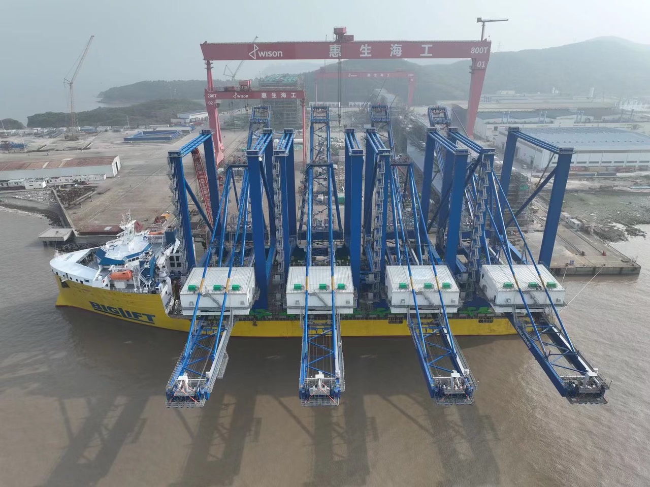 A set of four ship-to-shore container cranes loaded on a vessel ready for transport from China to the USA.