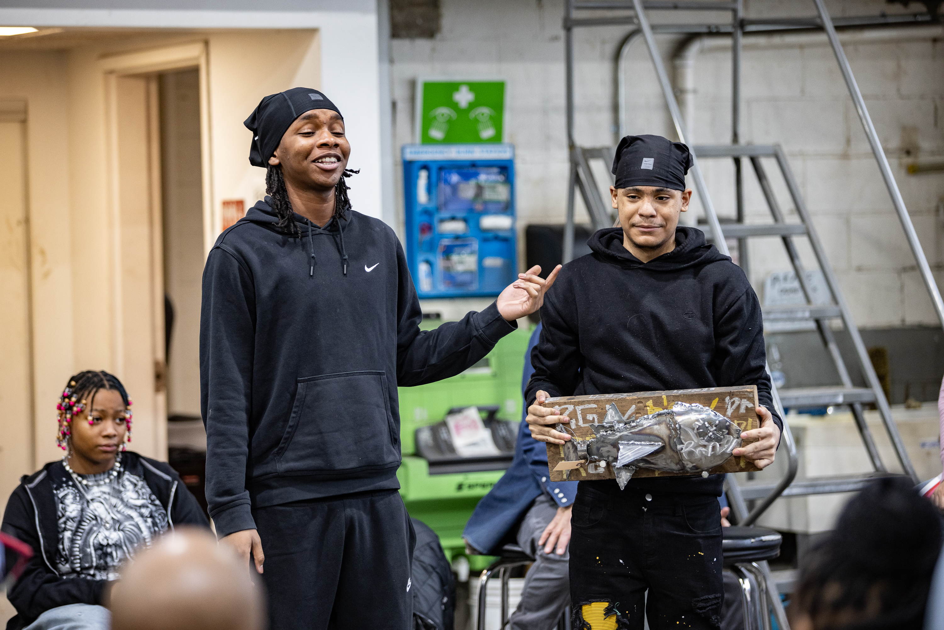 Rondal Gilmore (left) and Derico Riley (right) present their final project to their Weld Scholars cohort (Photos Courtesy of Industrial Arts Workshop)