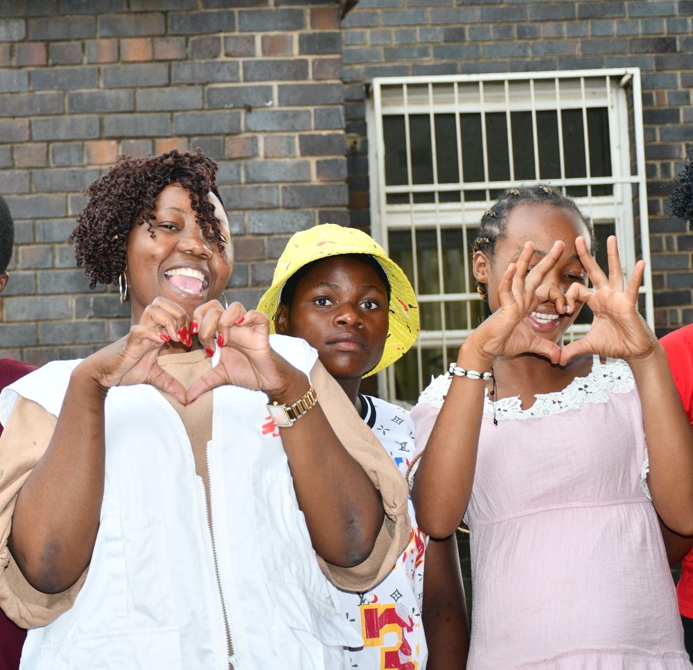MSF social work Relative Chitungo showed the teen mum how to make a love sign using their hands. Photographer: MSF | Location: Zimbabwe | Date: 22/11/2022
