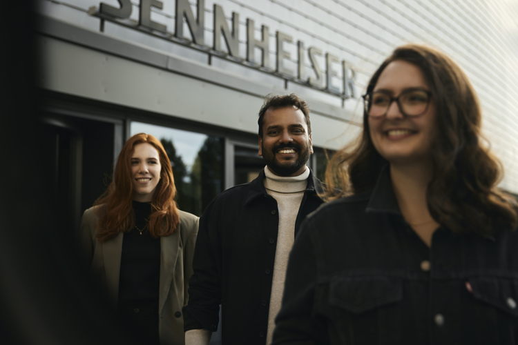 Sennheiser Mitarbeitende vor dem Hauptgebäude