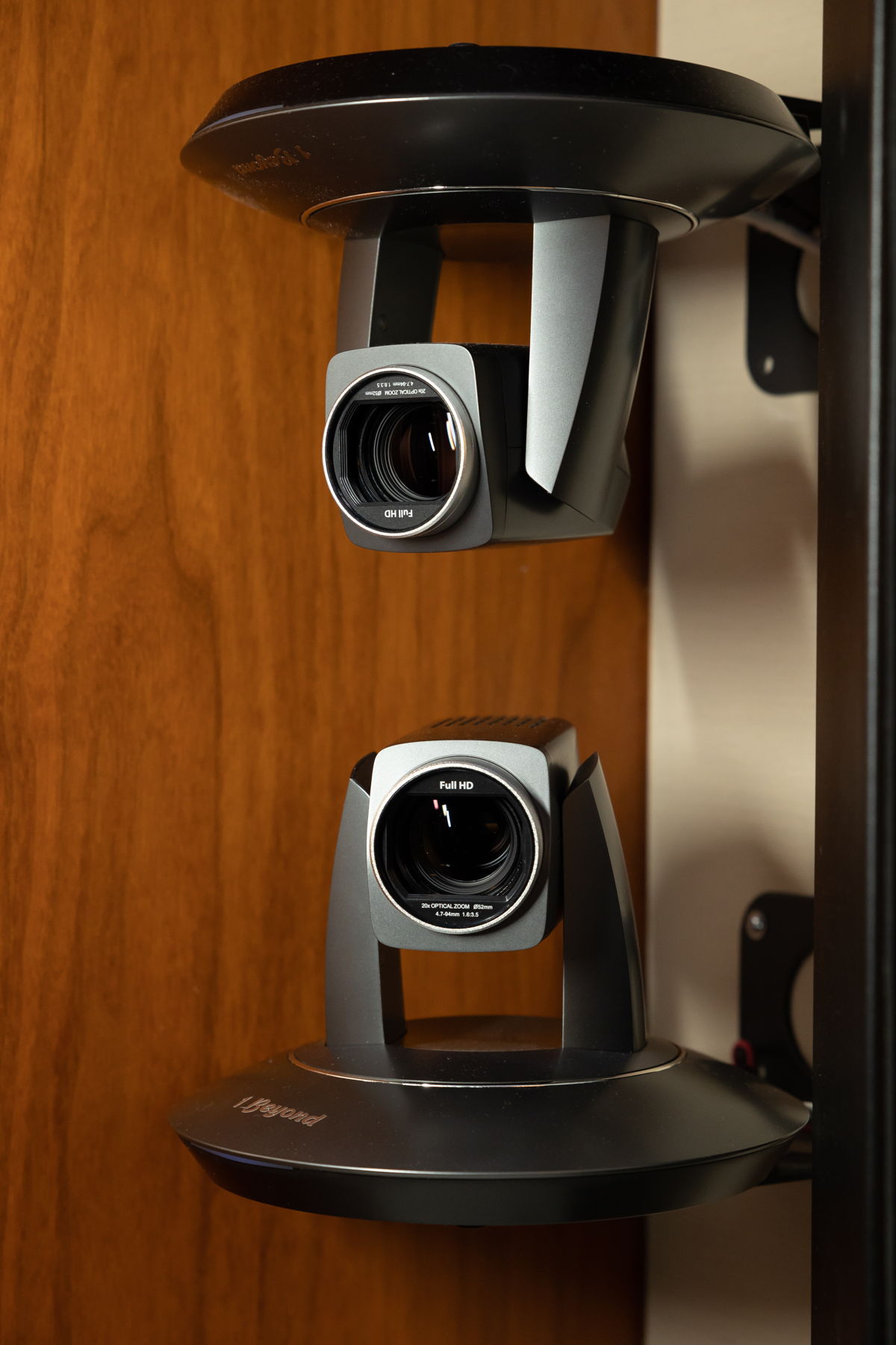 In the Board Room, Sennheiser TeamConnect Ceiling 2s are used to drive a 1 Beyond Autotracker system, which has seven built-in cameras. There are two 1 Beyond cameras on the left side of the room facing the right side, two on the right side facing the left side, and three at the center pointed at the end tables, the head of the table and a ‘default’ wide shot.