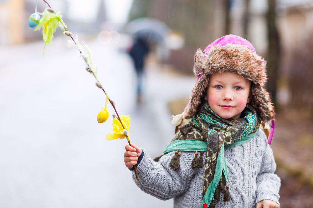 Kind mit selbst gestaltetem Osterpalmzweig