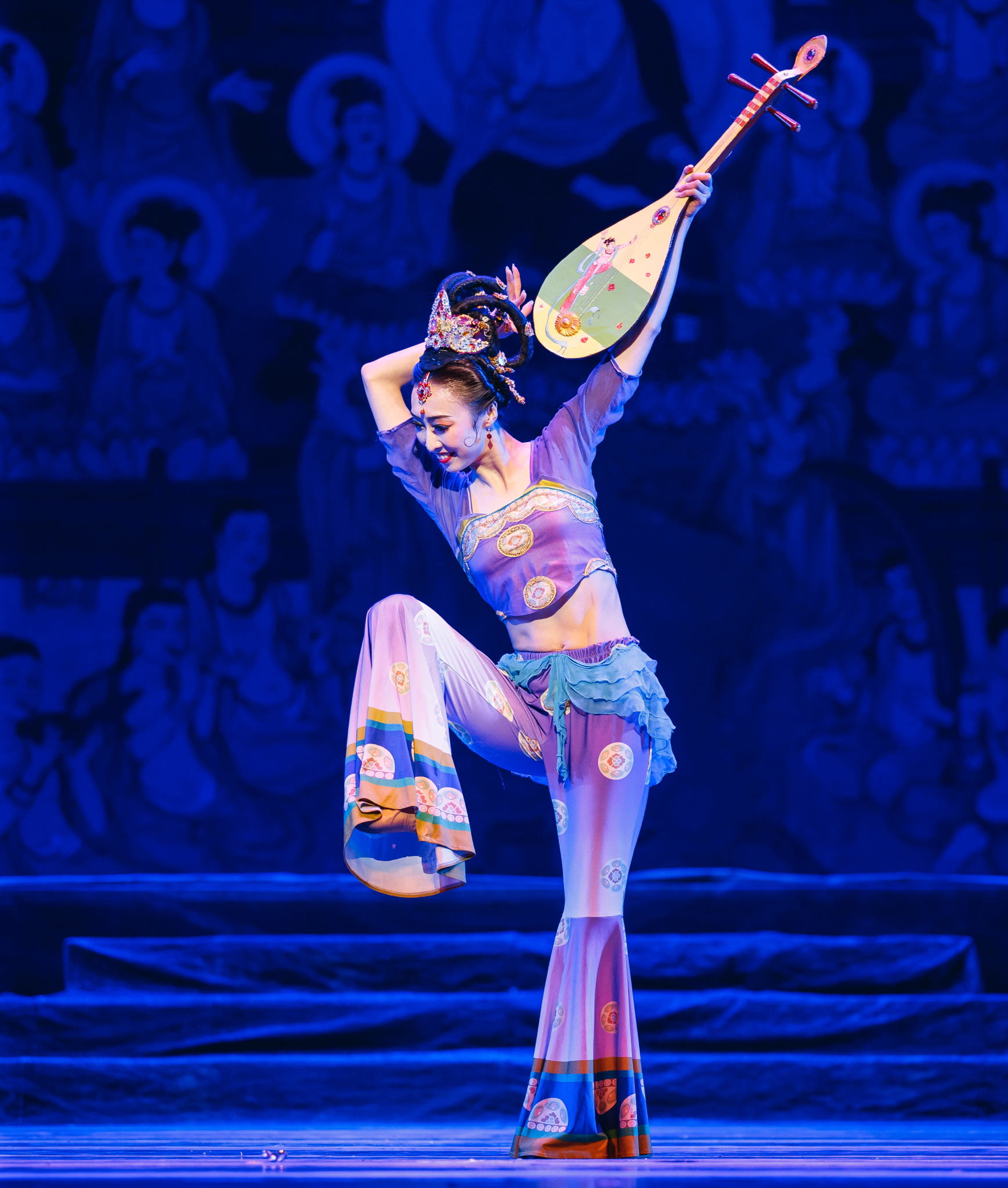 A woman performing on a stage while wearing a traditional Chinese costume.