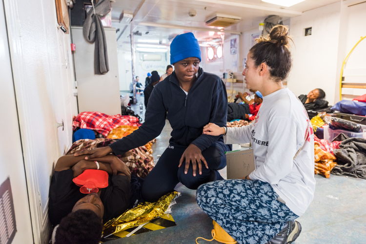 Catalina Arenas, MSF's humanitarian affairs officer, speaks to survivors after a rescue on January 27 2018. Copyright: Laurin Schmid/SOS MEDITERRANEE