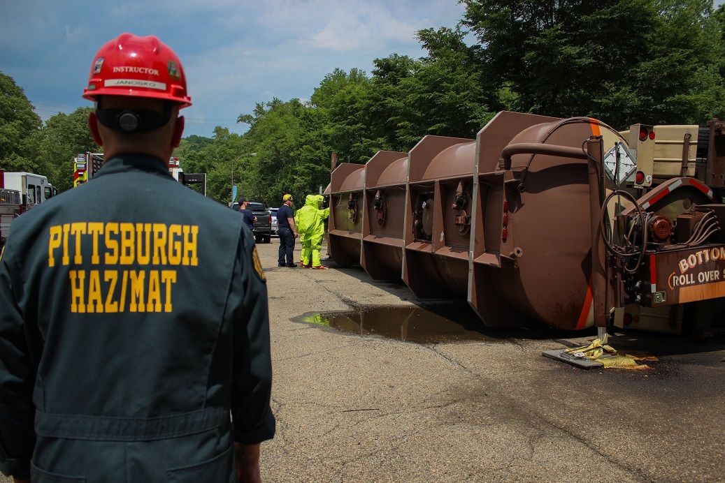 Crews from the Pittsburgh Bureau of Fire work during an exercise simulating an overturned tanker containing hazardous materials. The bureau teamed with Duquesne Light, which provided the hydraulic equipment to overturn the vessel. (Nick Ruffolo)