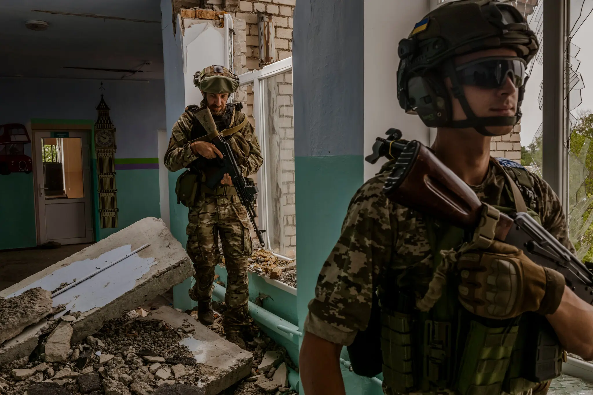 Ukrainian servicemen walking through a school bombed by Russian forces at the front line in the Mykolaiv region on Aug. 11. Daniel Berehulak for The New York Times.