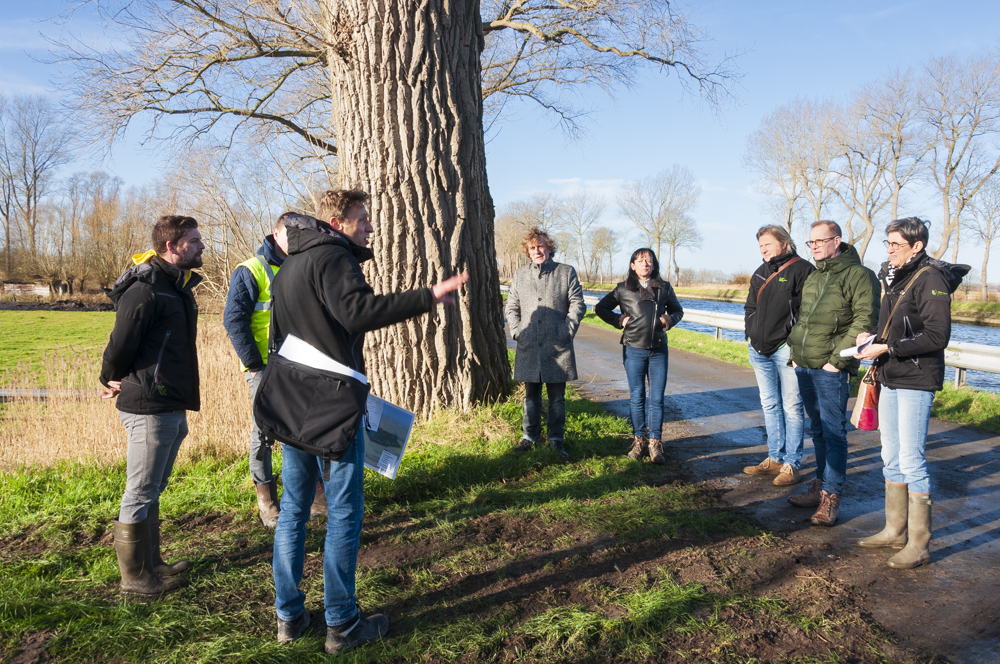 Burgemeester Frank Casteleyn en schepen Claudia Coudeville met medewerkers van de Vlaamse Landmaatschappij en aannemer Demaecker & Van Haecle NV langs het kanaal Brugge-Oostende in Kwetshage, waar je een goed zicht hebt op de terreinwerken.