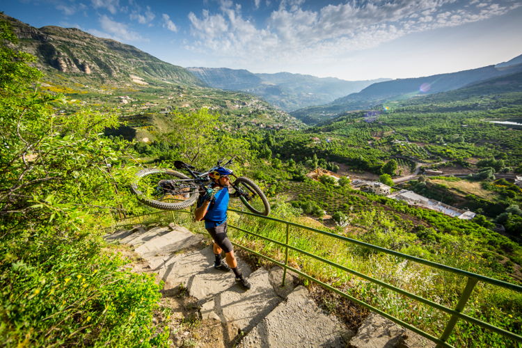 Kenny Belaey carries his bicycle during filming Border to Border in Aaqoura, Lebanon 