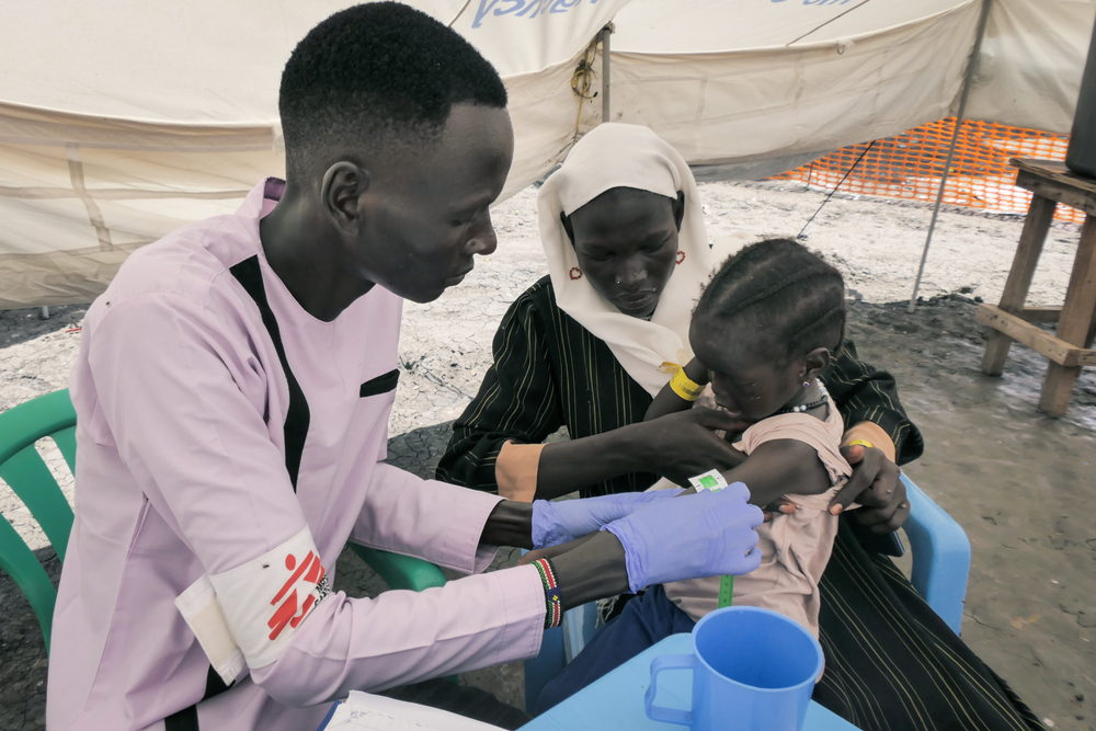 MSF Nurse Gatwech Tuoch measures Mid Upper Arm Circumference to screen malnutrition of a child, returning with family from Sudan, at the MSF Mobile Clinic in Bulukat, Upper Nile State. Photographer: Gale Julius Dada | Location: South Sudan| Date: 15/08/2023 MSF Nurse Gatwech Tuoch measures Mid Upper Arm Circumference to screen malnutrition of a child, returning with family from Sudan, at the MSF Mobile Clinic in Bulukat, Upper Nile State. Photographer: Gale Julius Dada | Location: South Sudan| Date: 15/08/2023