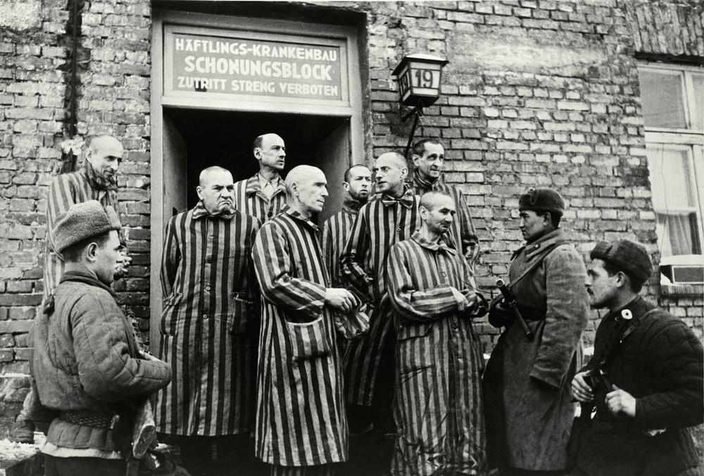 Soviet soldiers with former prisoners outside the entrance to the camp medical building, Auschwitz AKG143325 © akg-images