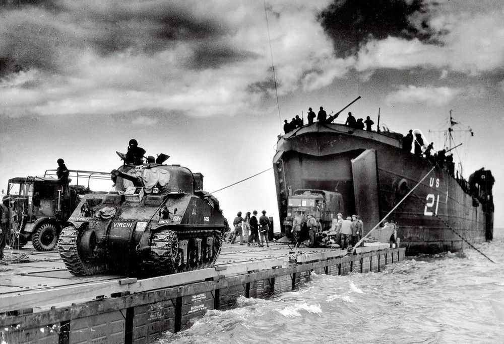 AKG9088474 Landing of the British 50th (Northumbrian) Division at Gold Beach in the Jig Green section near Arromanches-les-Bains: unloading of the US landing ship LST-21 (Landing, Ship, Tank) with a Rhino Ferry; on the left a Sherman tank of the 8th Independent Armoured Brigade. June 6, 1944 ©akg-images