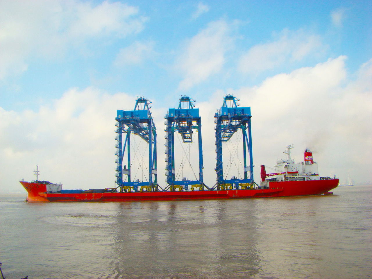 Three container cranes being shipped fully erect. Container cranes have kept up with vessel sizes by increasing their outreach, lift height, and even lift capacity.