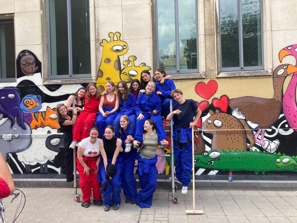 vlnr onderaan: Kaat, Loes, Lena en Luka; bovenaan: street artist MAU, Ana, Noor, Aubeline, Jitte, Rebecca, Vicky, Nette, Fee en Lars
