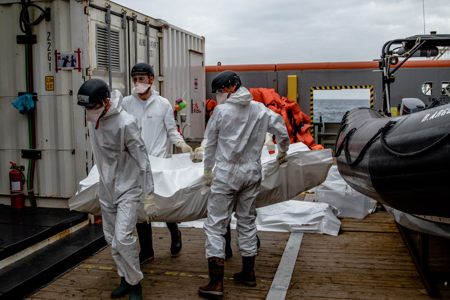 Des collaborateurs de MSF portent un corps à la morgue du Bourbon Argos. Le 17 novembre, le bateau de MSF a recueilli 27 personnes et 6 corps récupérés en mer par un navire de la marine britannique. © Borja Ruiz Rodriguez