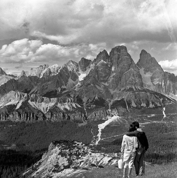 Tourists watching the Dolomites landscape after they got the Faloria hut. Cortina d’Ampezzo, 1950s Cortina d’Ampezzo, Italy. AKG2790846 © akg-images / Mondadori Portfolio Tourists watching the Dolomites landscape after they got the Faloria hut. Cortina d’Ampezzo, 1950s Cortina d’Ampezzo, Italy. AKG2790846 © akg-images / Mondadori Portfolio
