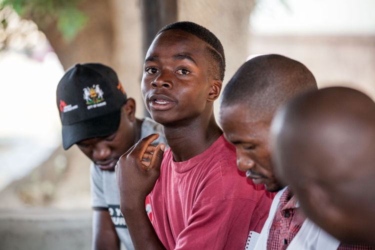 A peer educator shares his opinion in a group meeting. Photographer: Charmaine Chitate