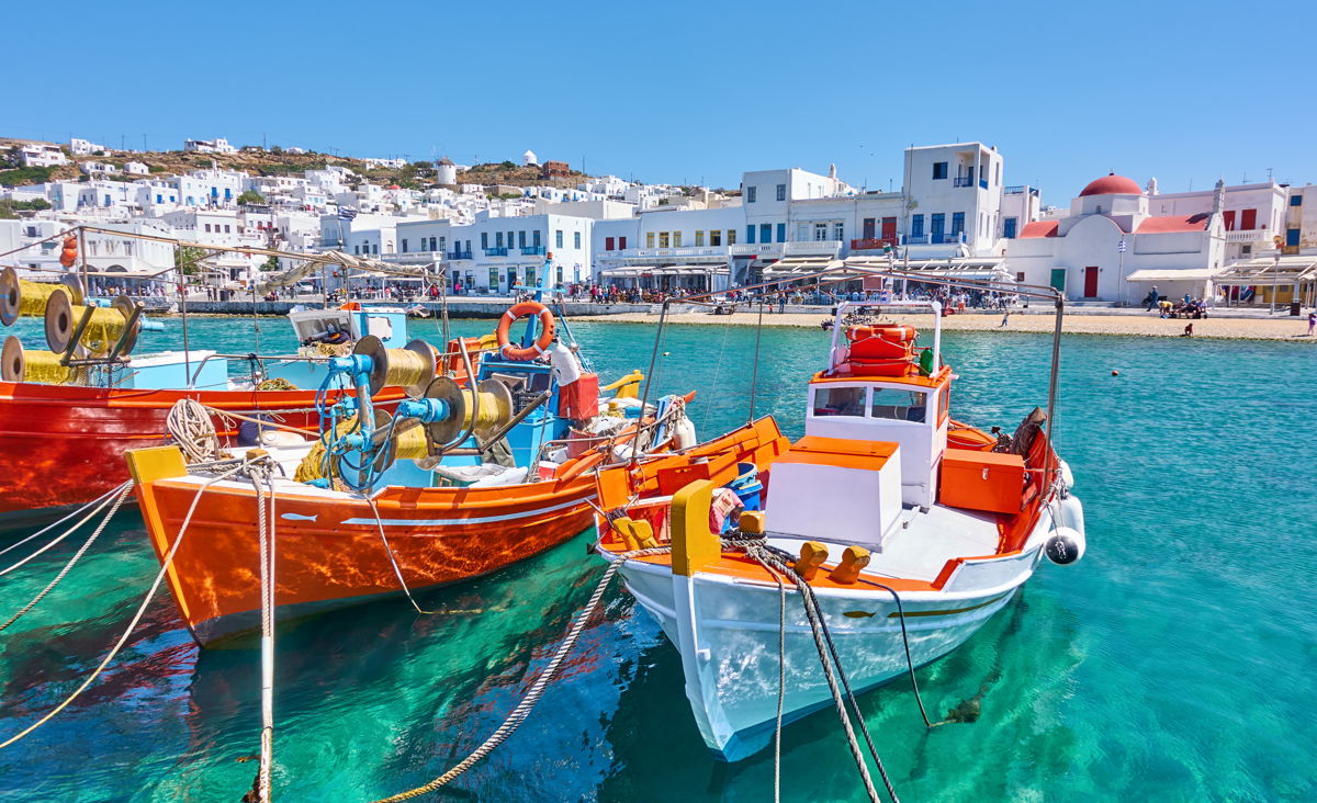 Harbor with wooden fishing boats in Chora town on a sunny summer day, Mykonos island, Greece 