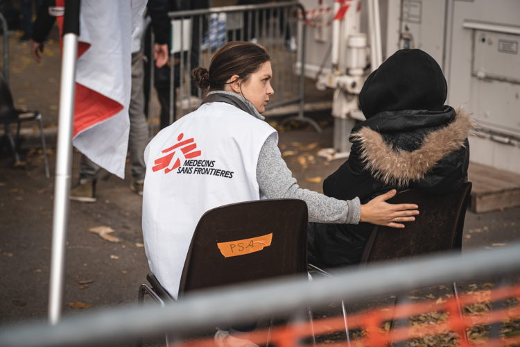 een patiënt wordt opgevangen door een medewerker van Artsen Zonder Grenzen aan Pacheco registratiecentrum (c) AZG/Pierre Fromentin
