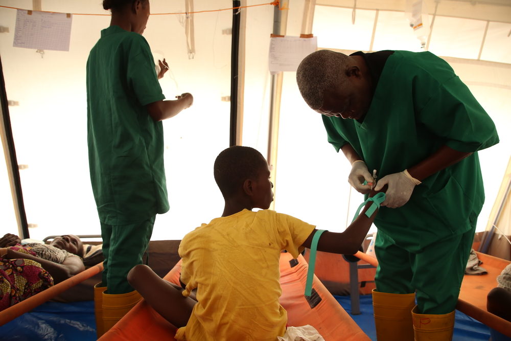Un infirmier MSF donne une solution de réhydratation à un patient souffrant du choléra © Carl Theunis