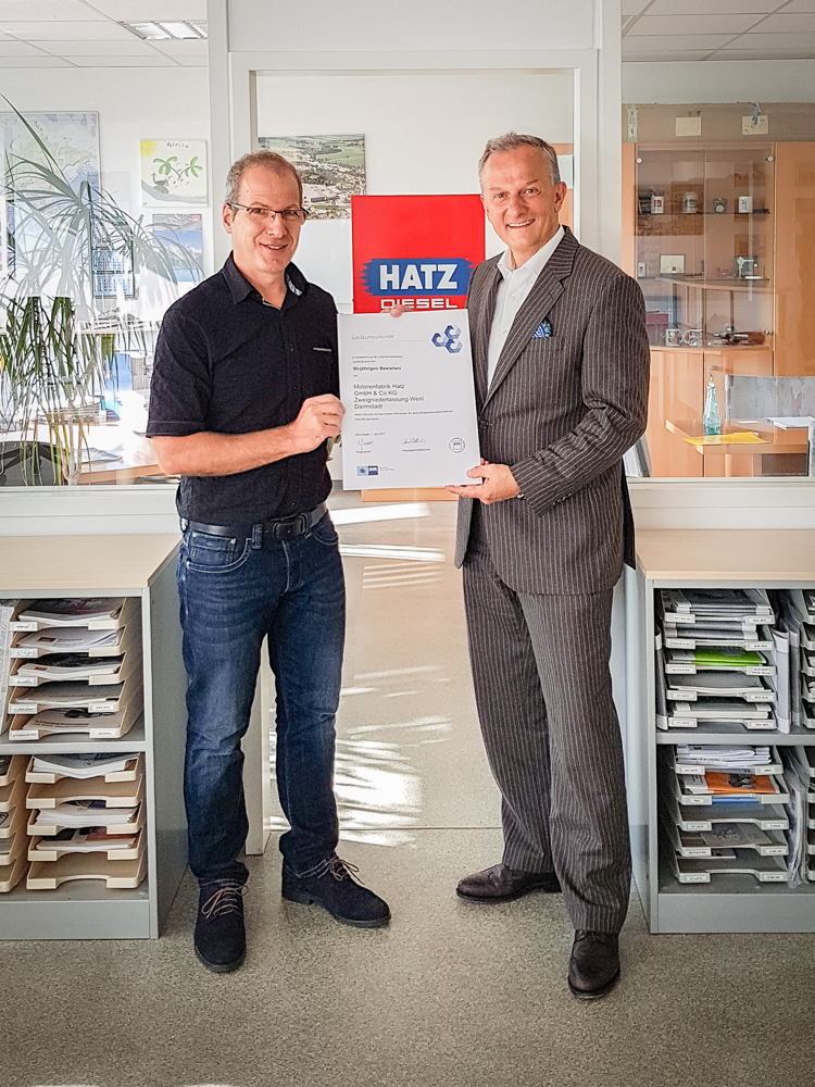 Hans-Heinrich Benda, Geschäftsbereichsleiter für Aus- und Weiterbildung der IHK Darmstadt (rechts), überreicht Kai Hopfensberger, Niederlassungsleiter Hatz West, die Urkunde zum 50-jährigen Bestehen