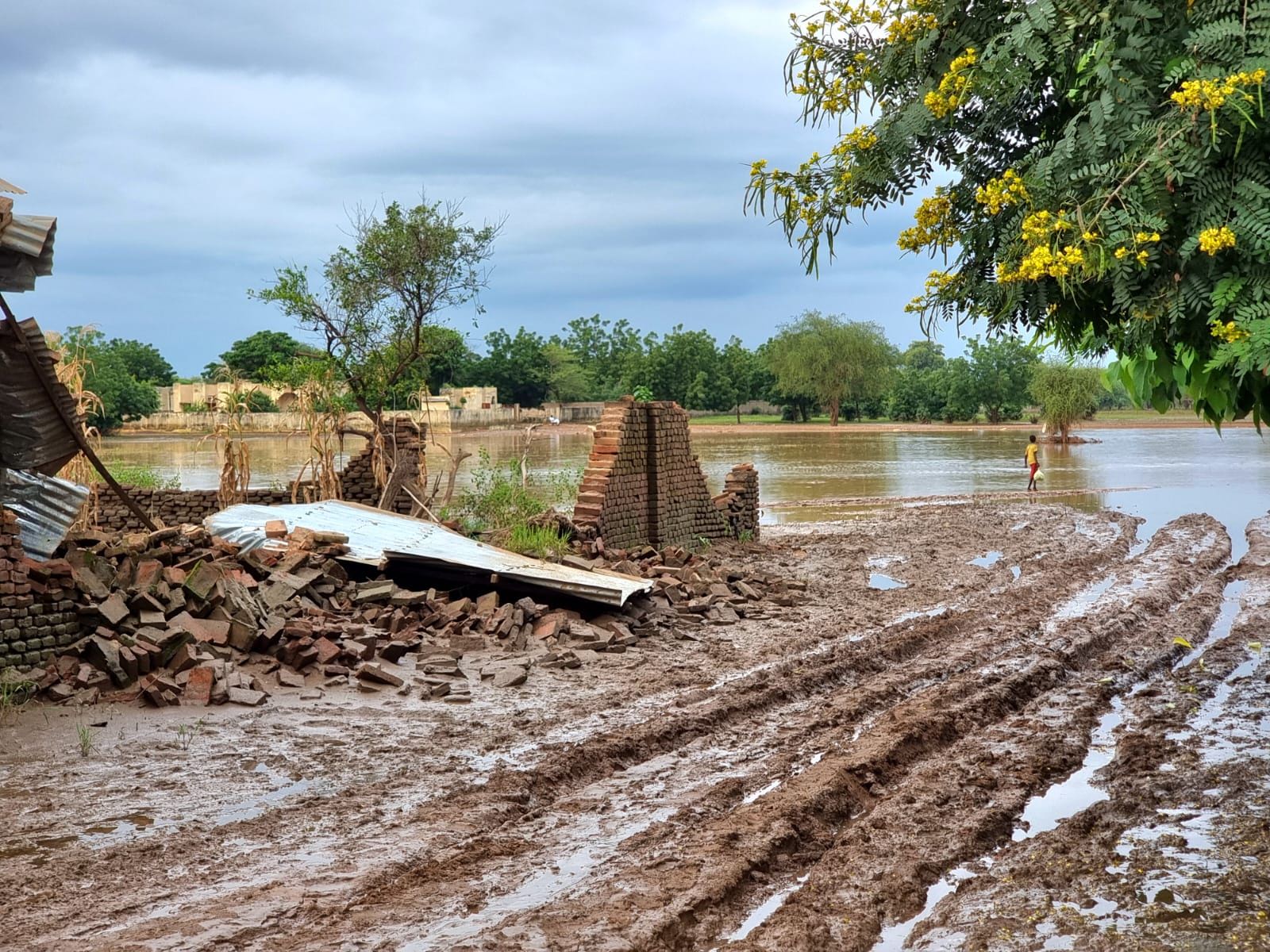 Un niño cruza aguas residuales para llegar al lugar donde se alojan los desplazados de la ciudad de Koukou, parcialmente destruida por las inundaciones. Julie Melichar/MSF