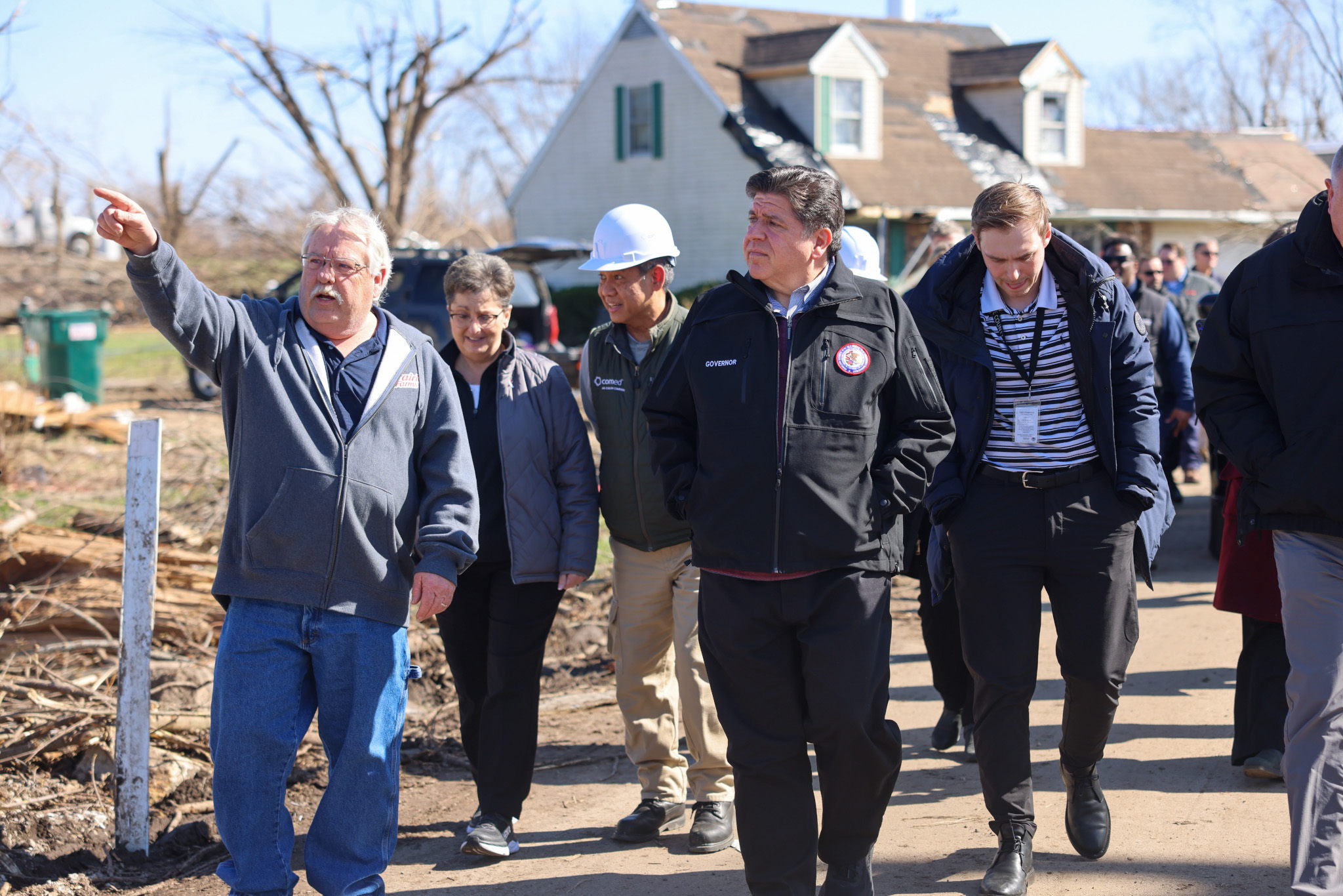 Governor Pritzker joins local officials, including Aroma Park Mayor Brian Stump (left), and others on the ground in Kankakee County to assess storm damages.