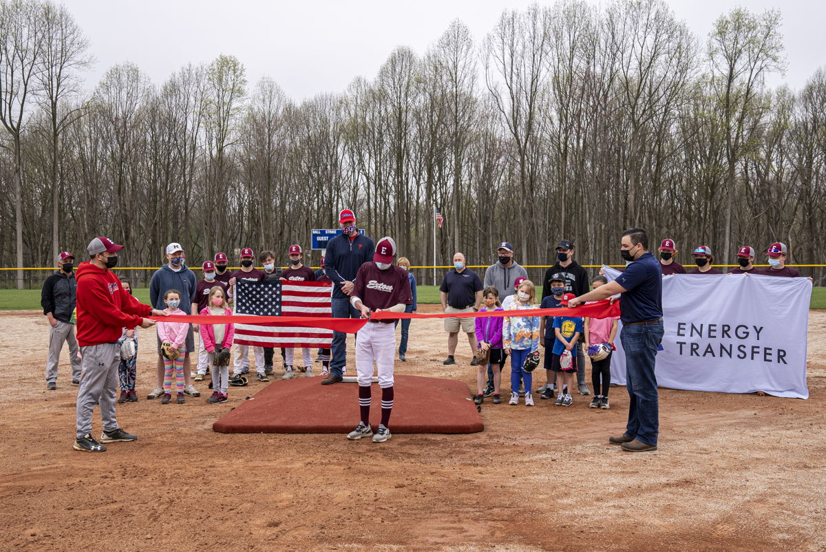 Baseball player cuts ribbon to celebrate Exton Little League's new fields and park facilities.