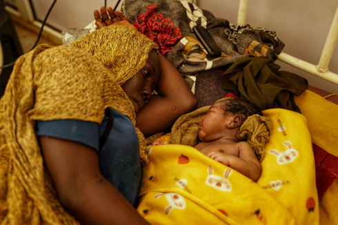 A woman cradles her two-day-old newborn in the MSF maternity ward in Um Rakuba camp, Al Gedaref State. November 2024.