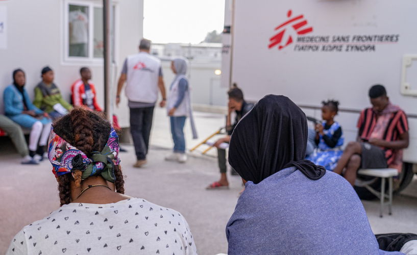 Medium shot of patients in the waiting area outside the mobile clinic in the Closed Control Access Centre in Zervou, Samos. MSF provides primary -including sexual and reproductive health care services by deploying a mobile clinic and team into the closed camp three times per week. A health promotion team is also visiting the camp to discuss and implement hygiene practices and ensure that people in the camp are aware of the support MSF can provide to its patients as a medical humanitarian organisation. Photographer: Evgenia Chorou/MSF| Location: Zervou, Samos, Greece | Date: 29/09/2022 Medium shot of patients in the waiting area outside the mobile clinic in the Closed Control Access Centre in Zervou, Samos. MSF provides primary -including sexual and reproductive health care services by deploying a mobile clinic and team into the closed camp three times per week. A health promotion team is also visiting the camp to discuss and implement hygiene practices and ensure that people in the camp are aware of the support MSF can provide to its patients as a medical humanitarian organisation. Photographer: Evgenia Chorou/MSF| Location: Zervou, Samos, Greece | Date: 29/09/2022