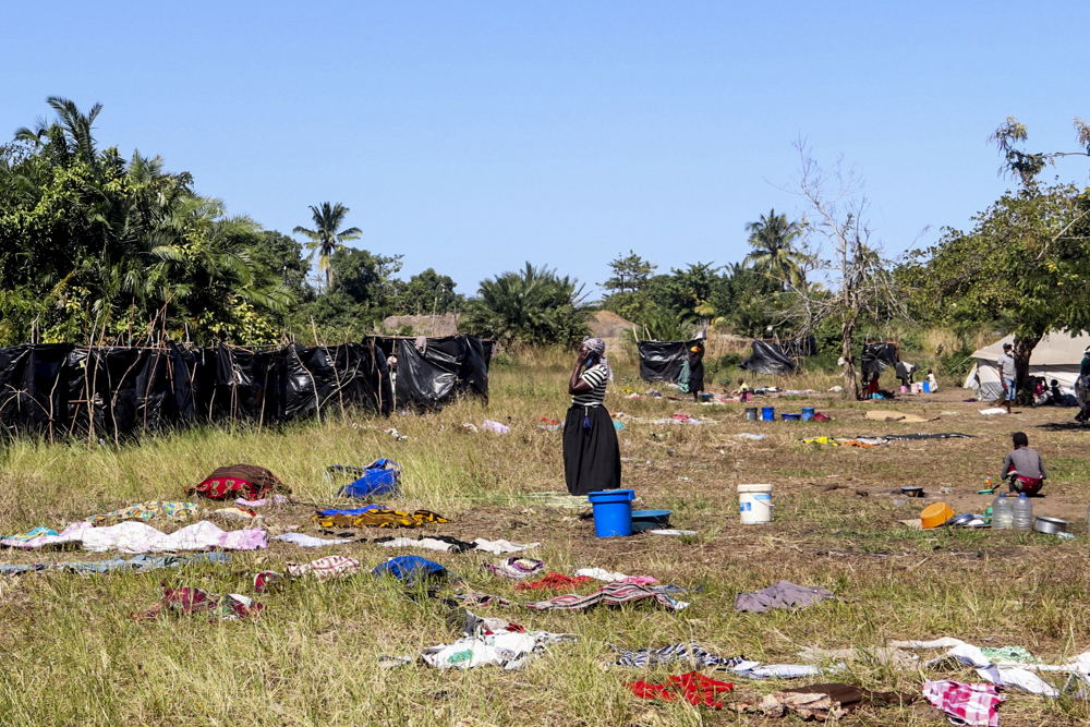 A woman stands in field where clothes are dried after washing in Metuge, Cabo Delgado Province. Make shift displace person camps have formed after a series of attacks has forced thousands to flee the north region. Photographer: MSF