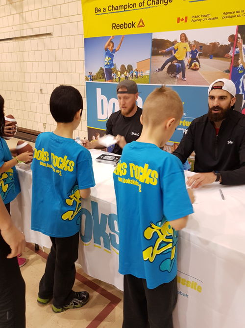 Bo Levi Mitchell and Brad Sinopoli signing autographs at Ecole Centennial Community School