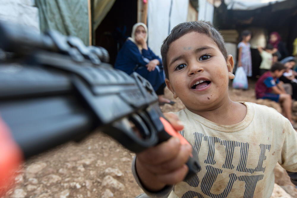 AKG9615382 Un petit garçon joue avec son pistolet en plastique au camp de réfugiés syriens à Ketermaya au Liban, en 2015 © Stefan Trappe / akg-images