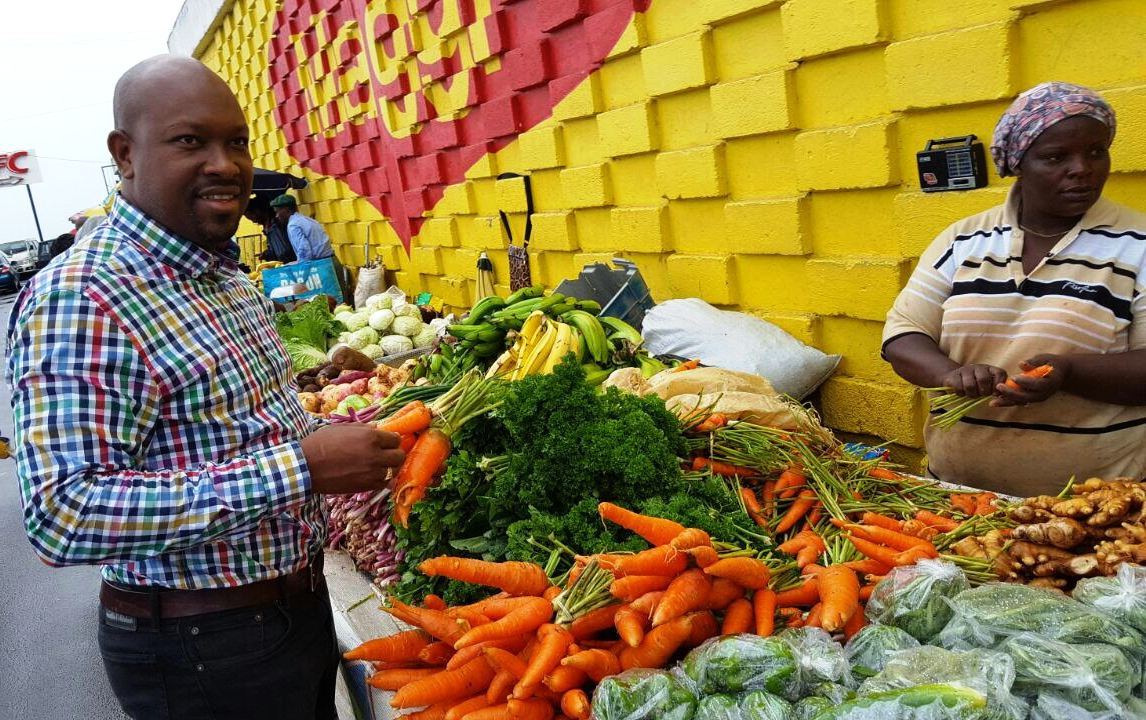Minister of Agriculture, Hon. Saboto Caesar, examines produce at local market.