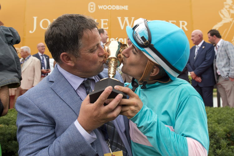 Kevin Attard and Rafael Hernandez kiss the Queen's Plate trophy after Moira's win in 2022 (Michael Burns Photo)