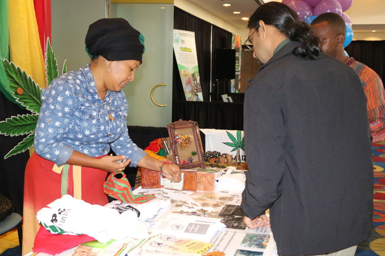 Participant in the Biodiversity Exposition explains products to visitors.
