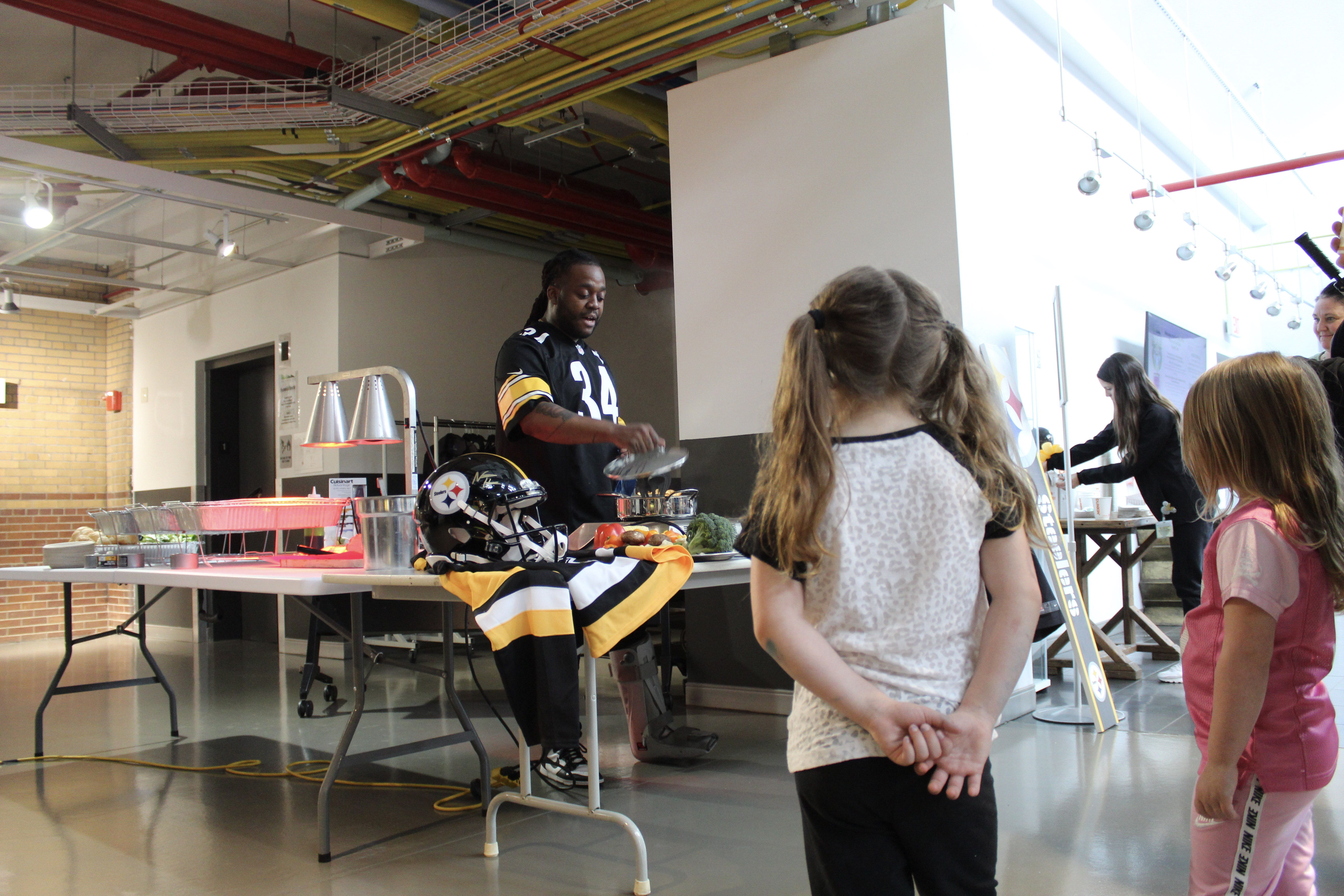 Chef Claudy Pierre gives s cooking demonstration on an induction cooktop during DLC's "Powered Up" event at the Energy Innovation Center in Pittsburgh's Hill District on April 22, 2023.