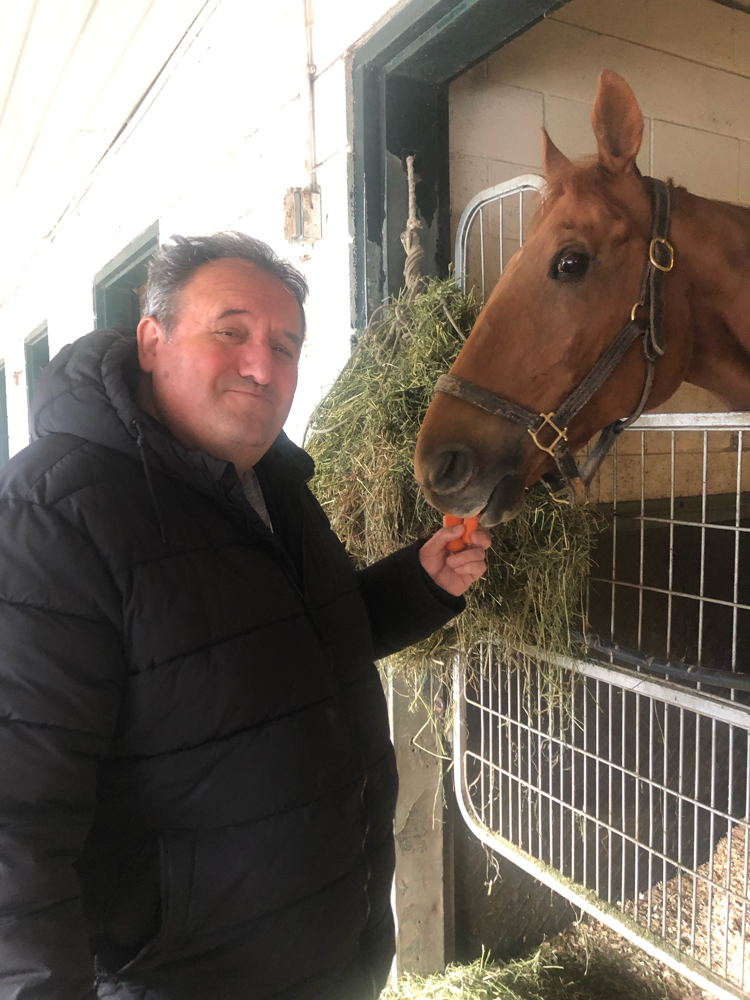 Co-owner of Eight Star Racing Stables Joe Mazarese feeding Lapochka carrots