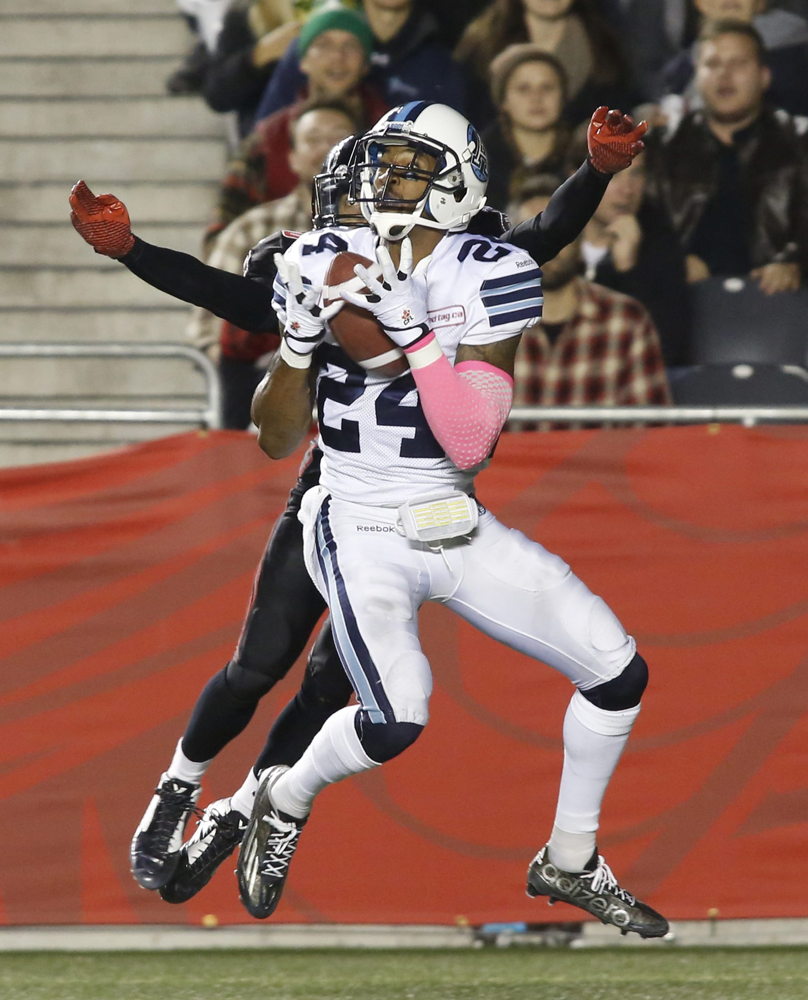Wearing a CFL Pink compression sleeve, Toronto Argonaut A.J. Jefferson makes an interception catch as Chris Williams jumps on Tuesday, October 6, 2015. (CFL PHOTO - Patrick Doyle)