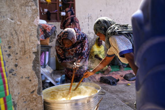 Women cooking inside the Al Tadamon schoolgrounds, Al Gedaref State. November 2024.