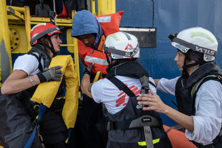 MSF team members Fulvia, Carolina and Nejma help an injured survivor board the ship during a rescue operation on 6 January 2023. Photographer Nyancho NwaNri. Date: 07/01/2023. Location: Mediterranean Sea MSF team members Fulvia, Carolina and Nejma help an injured survivor board the ship during a rescue operation on 6 January 2023. Photographer Nyancho NwaNri. Date: 07/01/2023. Location: Mediterranean Sea