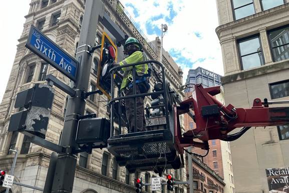 Electrical crews hanging a new traffic signal at Sixth Avenue and Wood Street