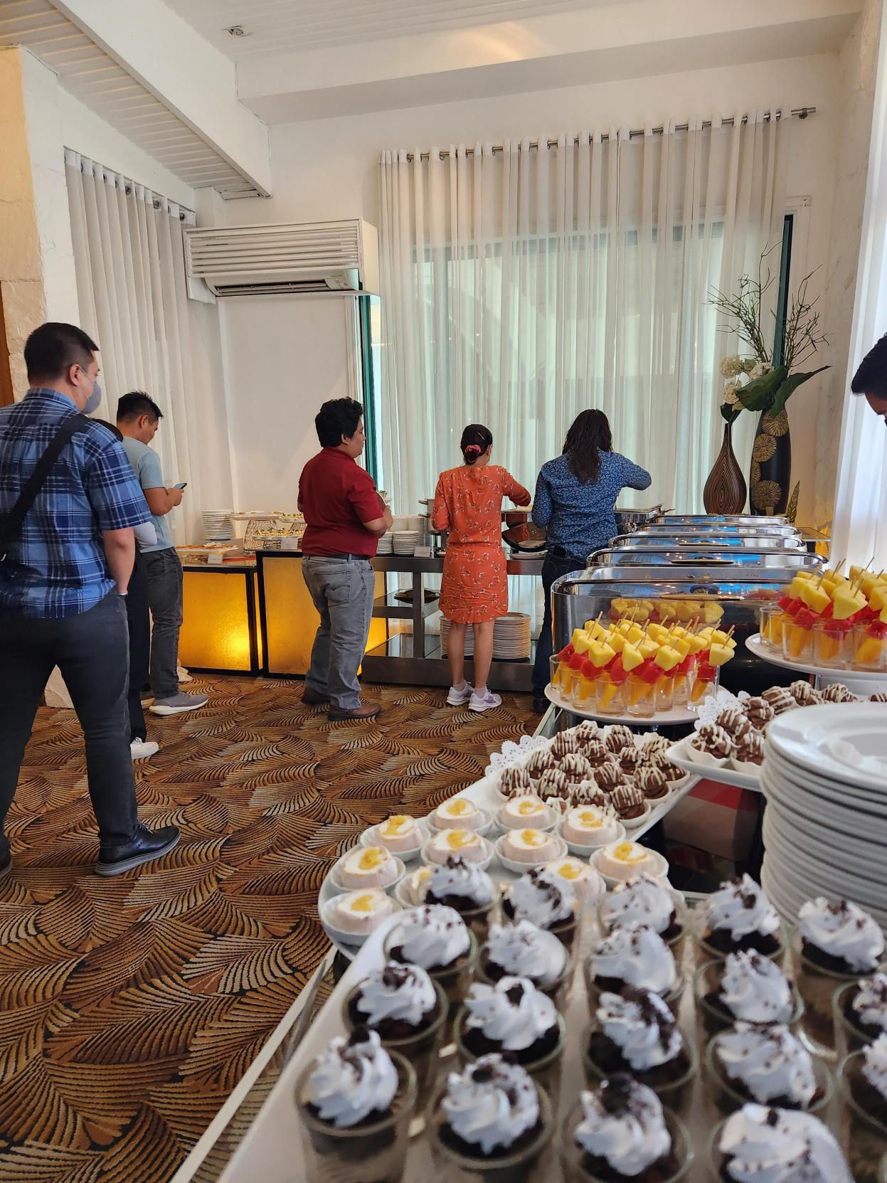 Attendees lining up for snacks and refreshments during the event Attendees lining up for snacks and refreshments during the event