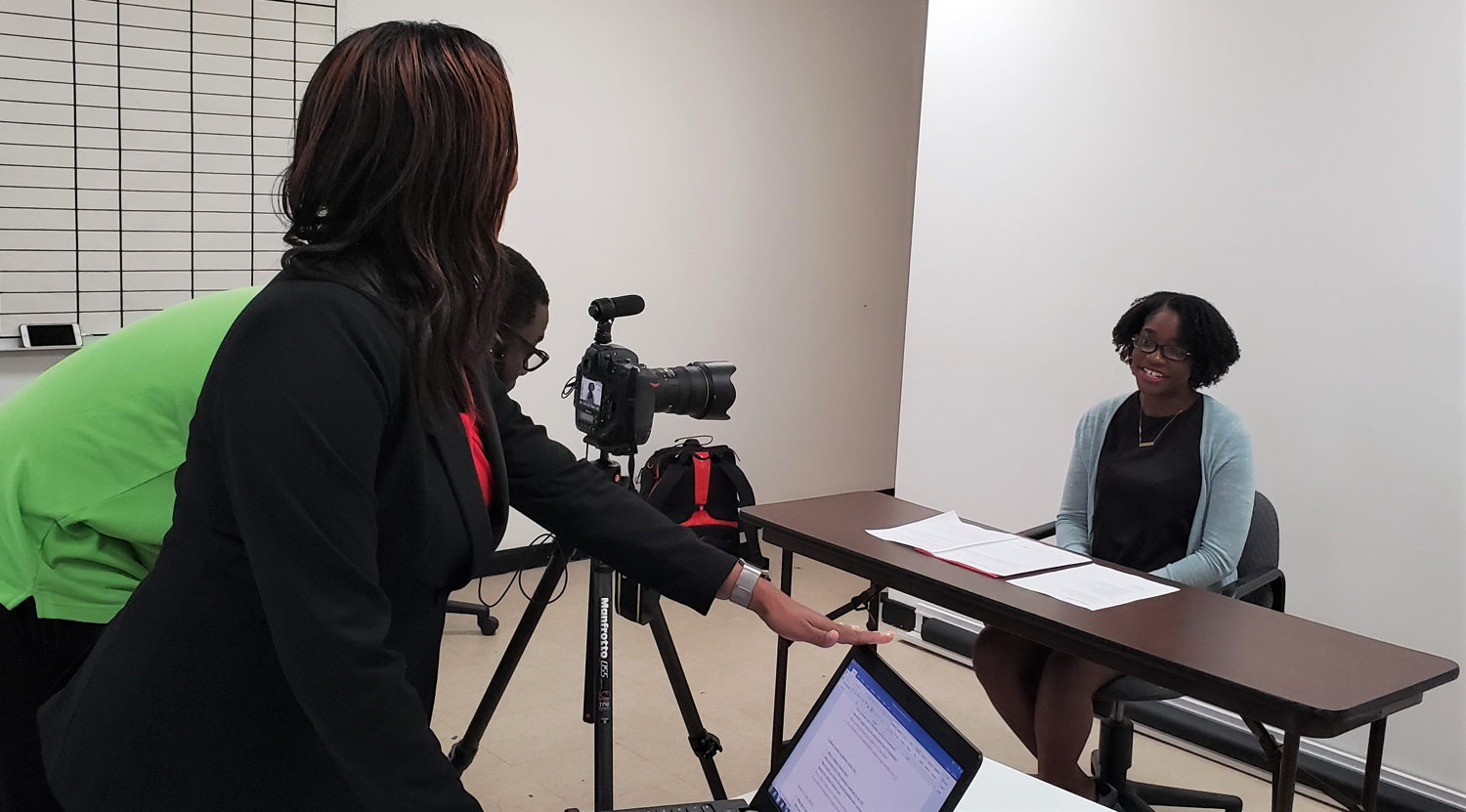 Facilitators engage participants in practical media relations sessions.