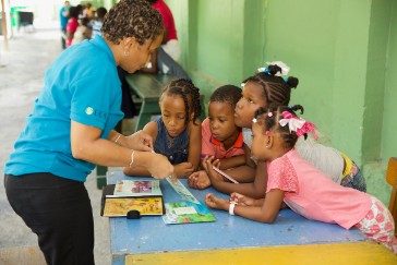 OECS Commission Staff reading to students as part of the USAID/OECS ELP 